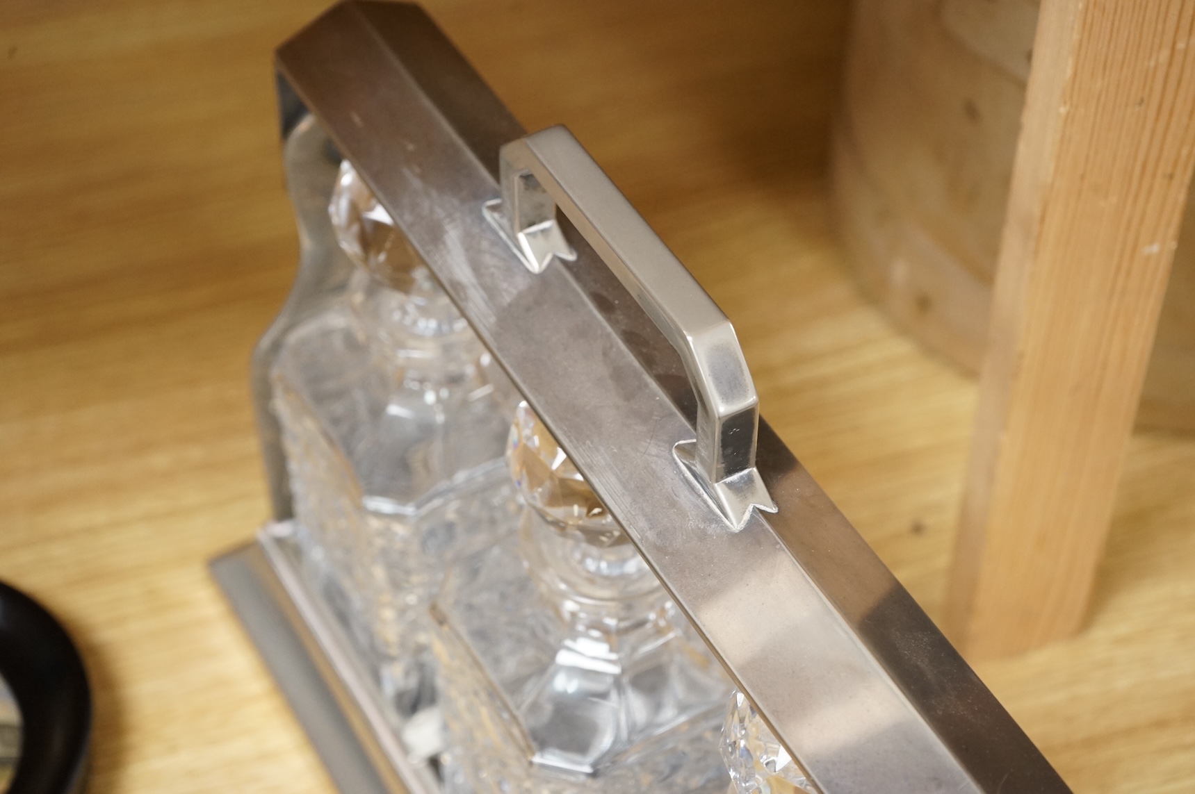 A silver plated three bottle tantalus, 34cm wide.